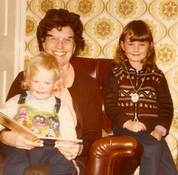 My grandmother, reading me a story, whilst my sister pretends to be angelic.
